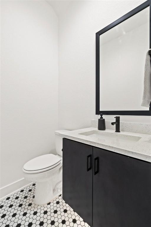 bathroom with tile patterned flooring, vanity, and toilet