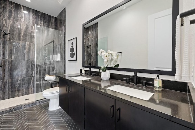 bathroom featuring vanity, toilet, and a tile shower