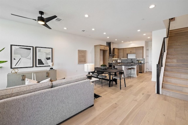 living room with ceiling fan, sink, and light hardwood / wood-style floors