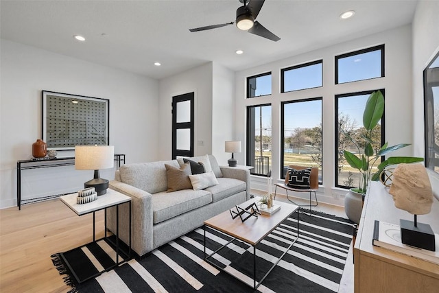 living room featuring ceiling fan and hardwood / wood-style flooring