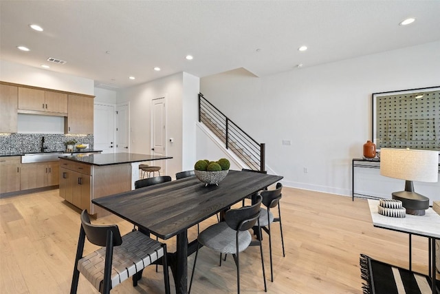 dining room with light hardwood / wood-style floors and sink