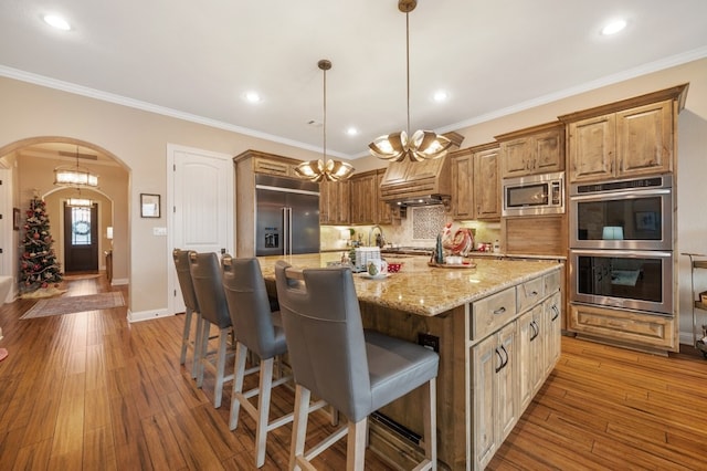 203 Serene Hilltop Cir, Lakeway, TX 78738 - kitchen with built in appliances, arched walkways, decorative backsplash, hardwood / wood-style floors, and ornamental molding