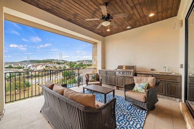 balcony with sink, ceiling fan, outdoor lounge area, a grill, and an outdoor kitchen