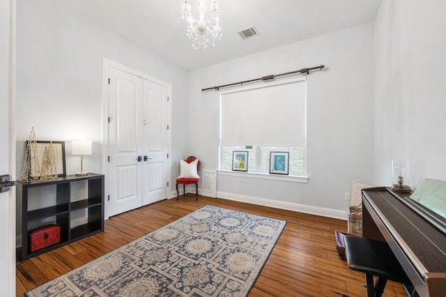 living area with hardwood / wood-style flooring and an inviting chandelier