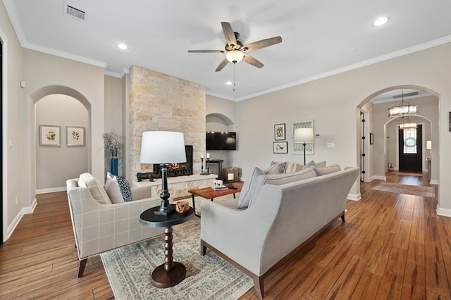 203 Serene Hilltop Cir, Lakeway, TX 78738 - living room featuring arched walkways, ceiling fan, wood-type flooring, a stone fireplace, and baseboards