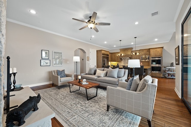 living room featuring dark wood-type flooring, ornamental molding, and ceiling fan