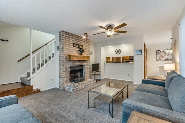 living room with carpet flooring, ceiling fan, a fireplace, and a textured ceiling