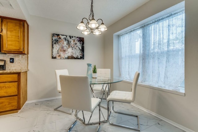 dining room featuring a textured ceiling, a wealth of natural light, and a notable chandelier