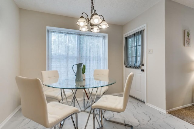 dining area with a chandelier and a textured ceiling