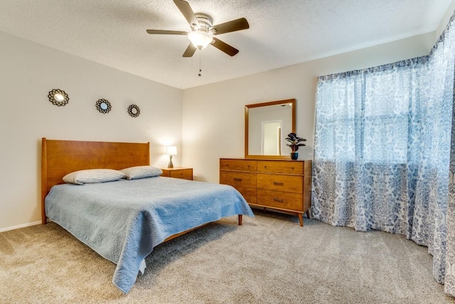 bedroom with ceiling fan, light carpet, and a textured ceiling