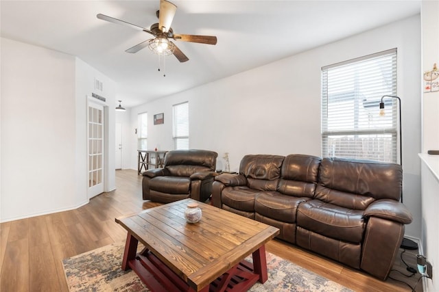 living room featuring ceiling fan and light hardwood / wood-style flooring