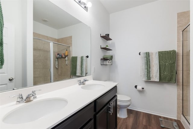 bathroom with hardwood / wood-style floors, vanity, toilet, and an enclosed shower