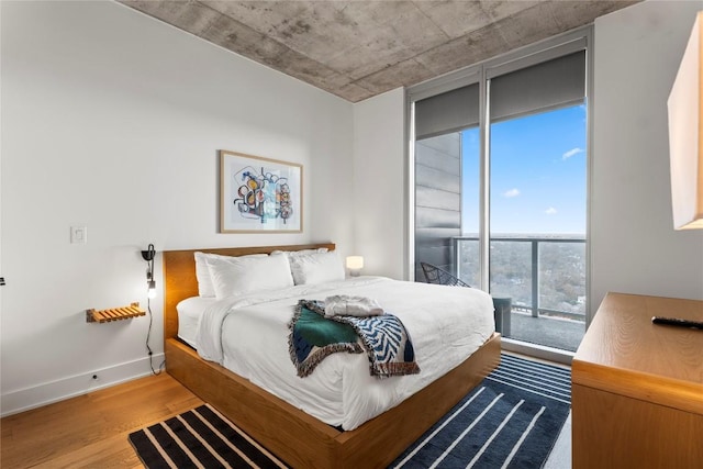 48 E Ave Unit 2506, Austin, TX 78701 - bedroom with wood finished floors, access to exterior, and baseboards