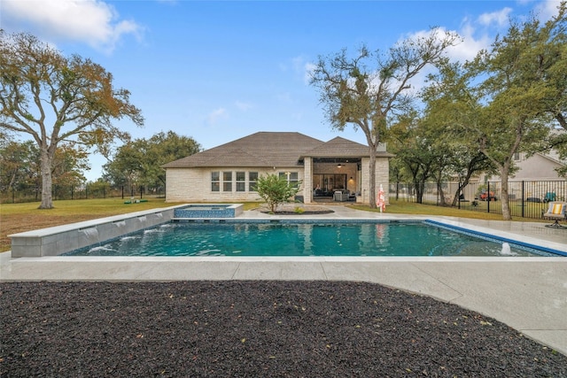 view of swimming pool featuring an in ground hot tub and a lawn