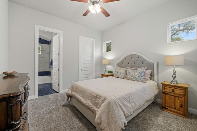 bedroom featuring ensuite bath, ceiling fan, and dark carpet