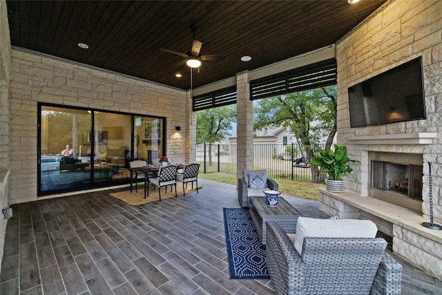 view of patio / terrace with ceiling fan and an outdoor stone fireplace