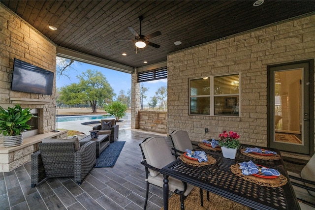 view of patio featuring ceiling fan and an outdoor stone fireplace