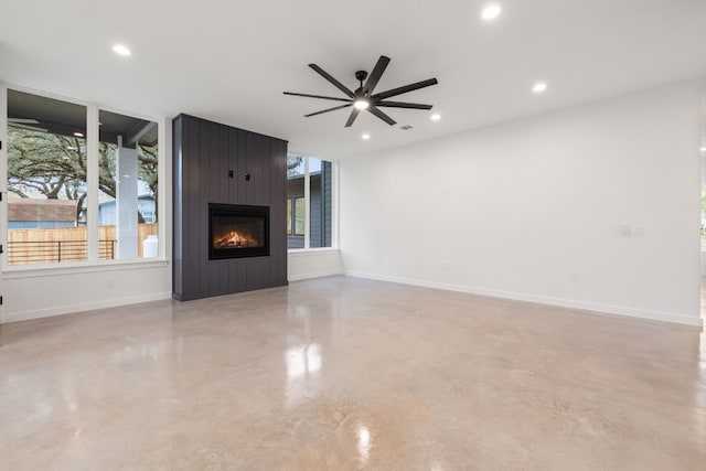 unfurnished living room with ceiling fan and a fireplace