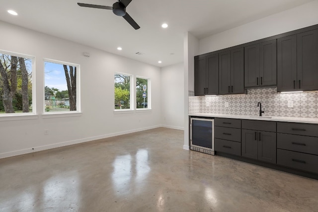 kitchen featuring decorative backsplash, ceiling fan, sink, and beverage cooler