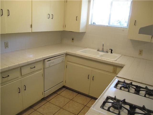 kitchen featuring tile counters, sink, white appliances, decorative backsplash, and light tile patterned floors