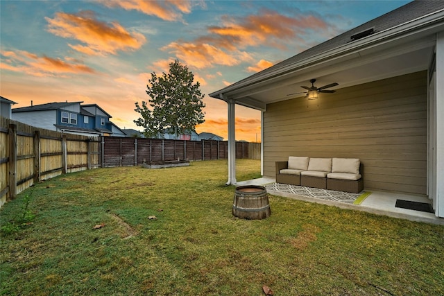 yard at dusk featuring ceiling fan