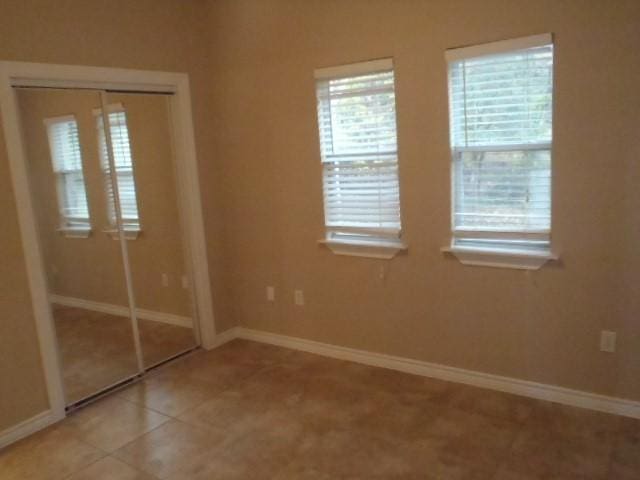 unfurnished bedroom with light tile patterned floors and a closet