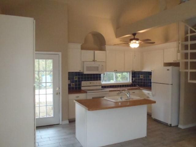 kitchen with a center island with sink, white cabinets, and white appliances