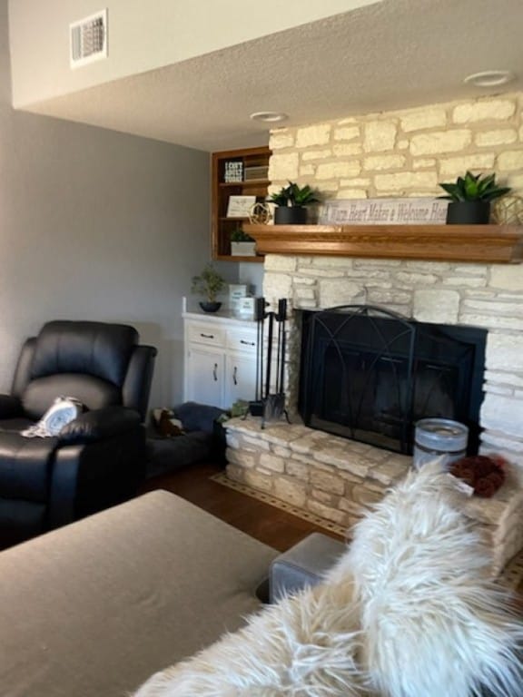 living room featuring a fireplace, hardwood / wood-style floors, and a textured ceiling