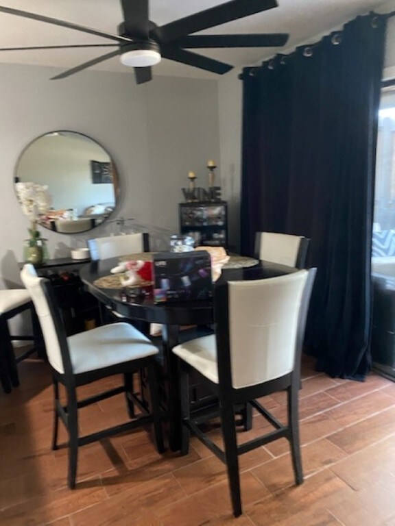 dining area with ceiling fan and wood-type flooring