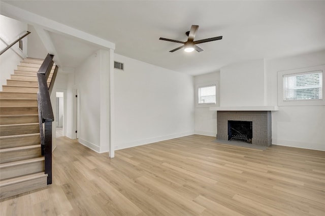 unfurnished living room featuring a fireplace, a healthy amount of sunlight, and light hardwood / wood-style floors