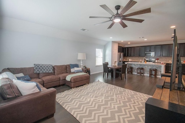 living room featuring wood-type flooring and ceiling fan