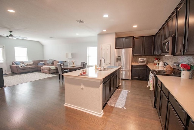 kitchen with hardwood / wood-style flooring, sink, an island with sink, and appliances with stainless steel finishes