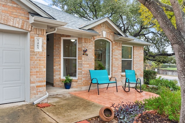 view of exterior entry with a patio area