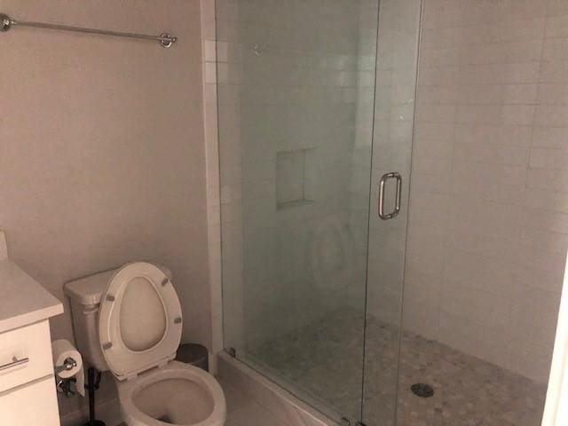 bathroom featuring vanity, toilet, and walk in shower