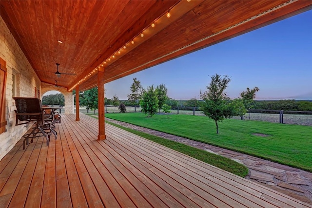 wooden terrace featuring a lawn