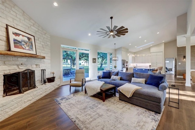 living room featuring ceiling fan, a fireplace, dark hardwood / wood-style floors, and lofted ceiling