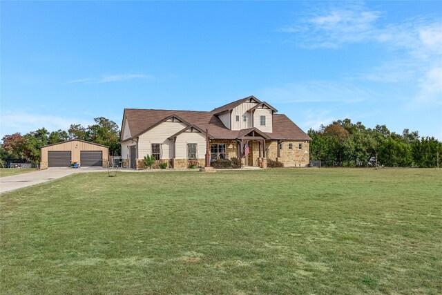 view of front of home featuring a garage, an outdoor structure, and a front lawn