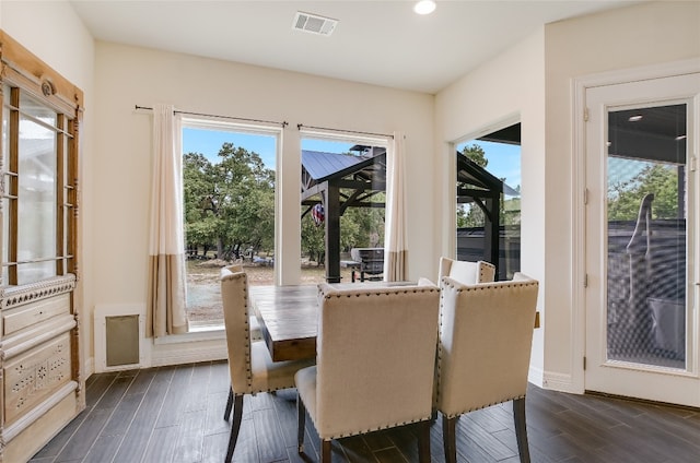 dining area with a wealth of natural light and dark wood-type flooring