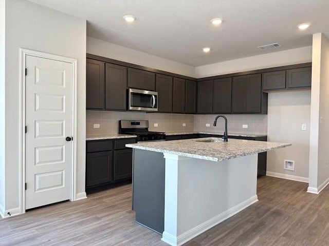2143 Tobias Leo Way, Round Rock, TX 78665 - kitchen featuring stainless steel appliances, decorative backsplash, light wood finished floors, and recessed lighting