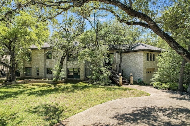 3901 Prentice Ln, Austin, TX 78746 - view of front facade with stairway, stone siding, a front lawn, and an attached garage