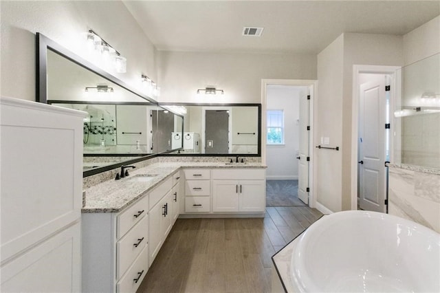 bathroom with vanity, hardwood / wood-style floors, and a bathtub