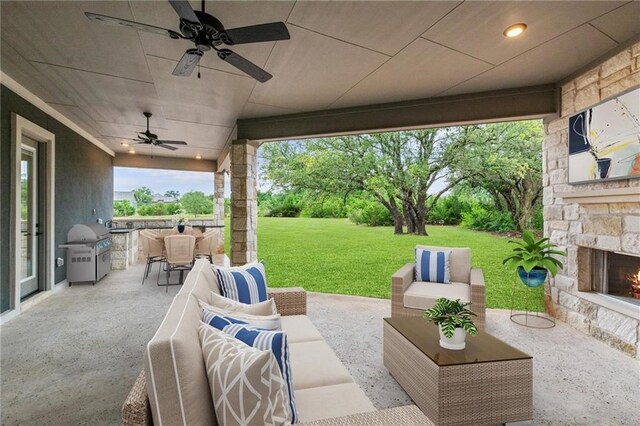 view of patio featuring an outdoor living space with a fireplace, ceiling fan, and a grill