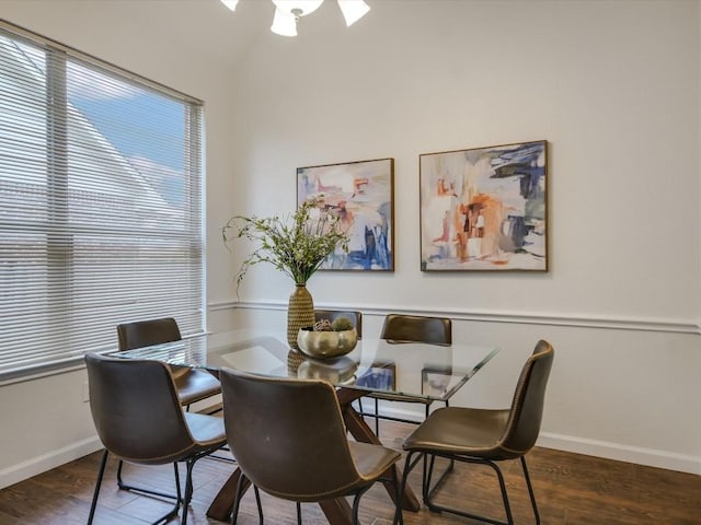 dining area featuring vaulted ceiling and dark wood-type flooring