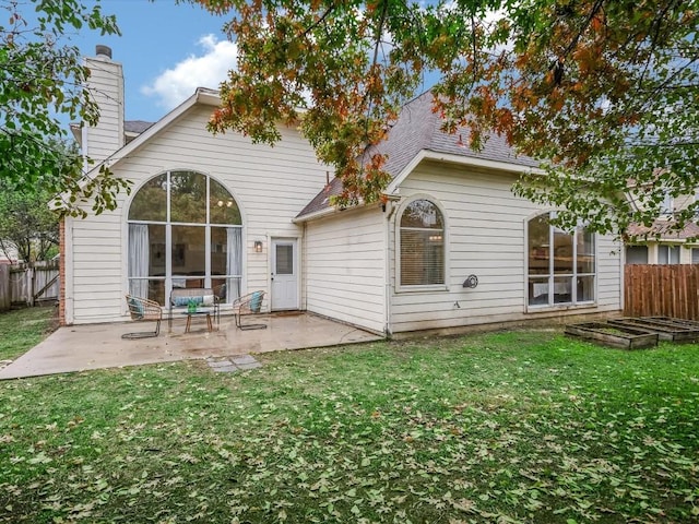 rear view of house featuring a yard and a patio