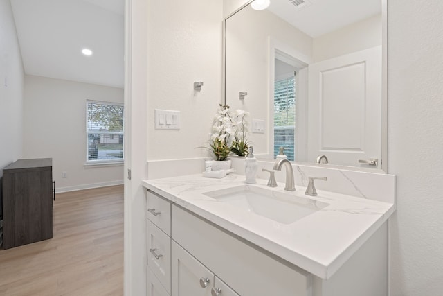 bathroom with a wealth of natural light, vanity, and hardwood / wood-style flooring