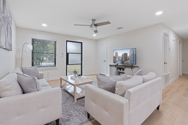 living room with ceiling fan and light hardwood / wood-style flooring