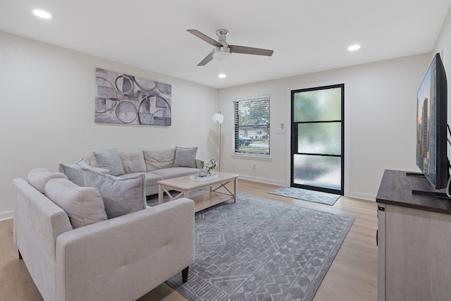 living room featuring ceiling fan and light hardwood / wood-style floors