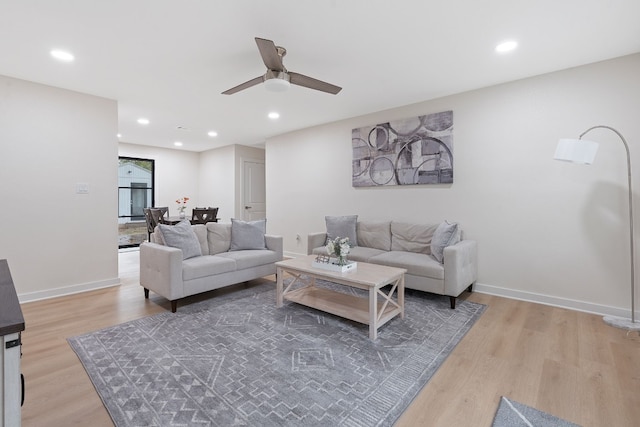 living room with ceiling fan and light hardwood / wood-style floors