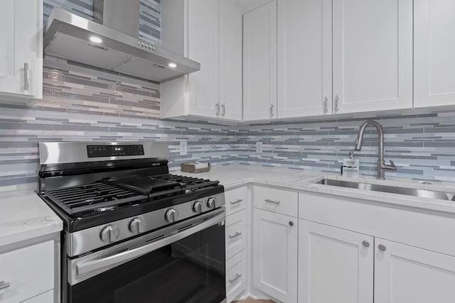 kitchen featuring white cabinets, sink, wall chimney exhaust hood, and stainless steel range with gas stovetop