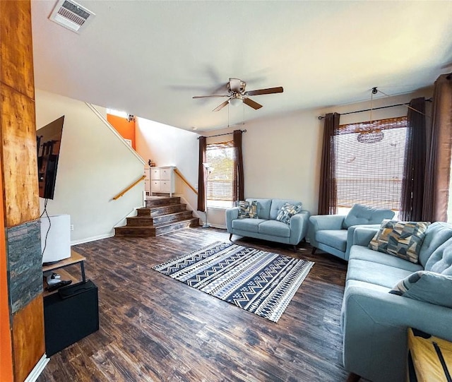 living room with dark wood-type flooring and ceiling fan with notable chandelier